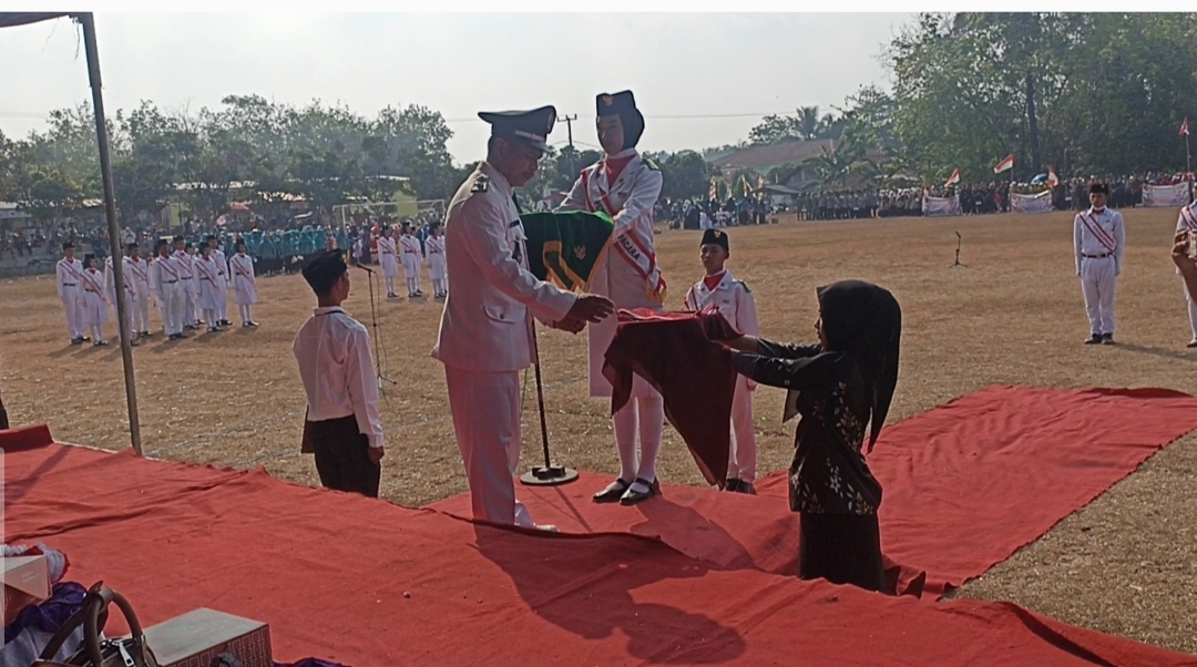 Prosesi upacara penaikan bendera merah outih di Desa Tanjung Makmur.